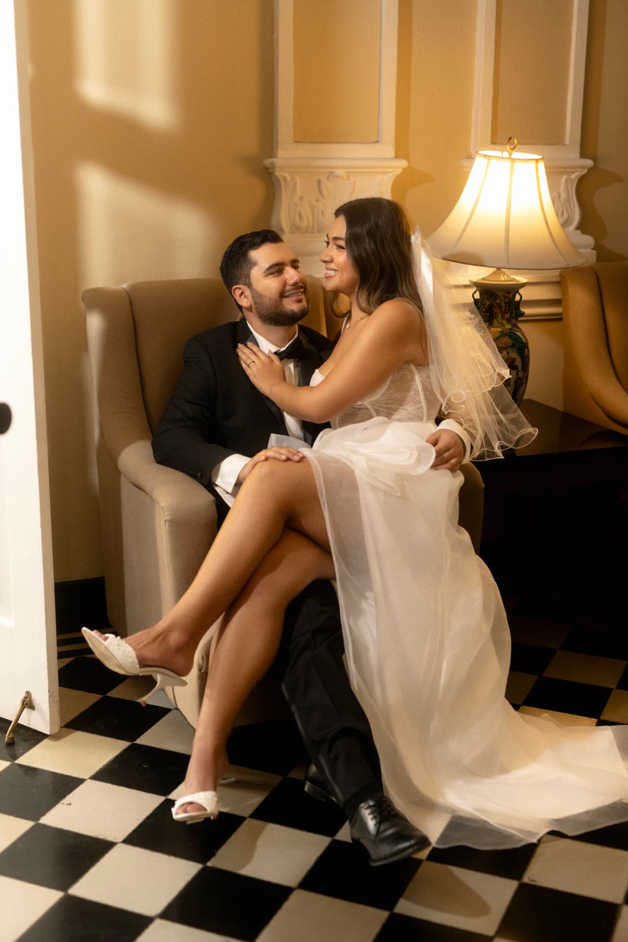 Angie Paulet sentada sobre Juan Diego en un sillón