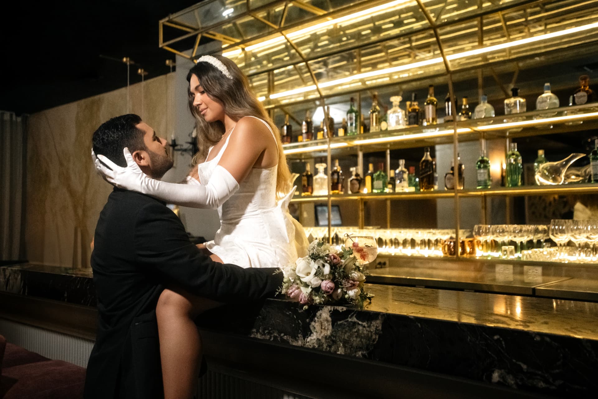 Angie Paulet sentada en la barra junto a Juan Diego