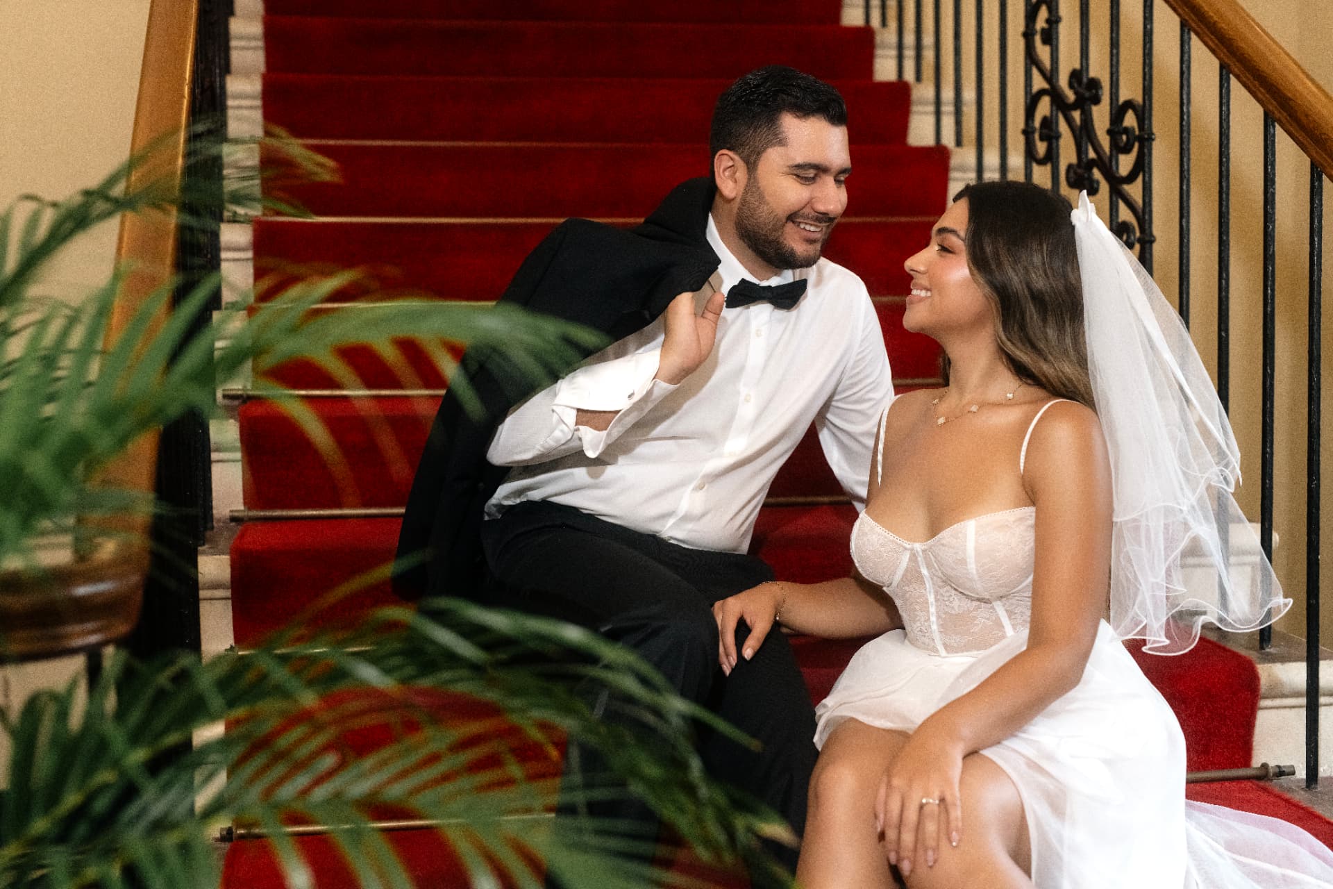Angie Paulet y Juan Diego sentados en la escalera de alfombra roja